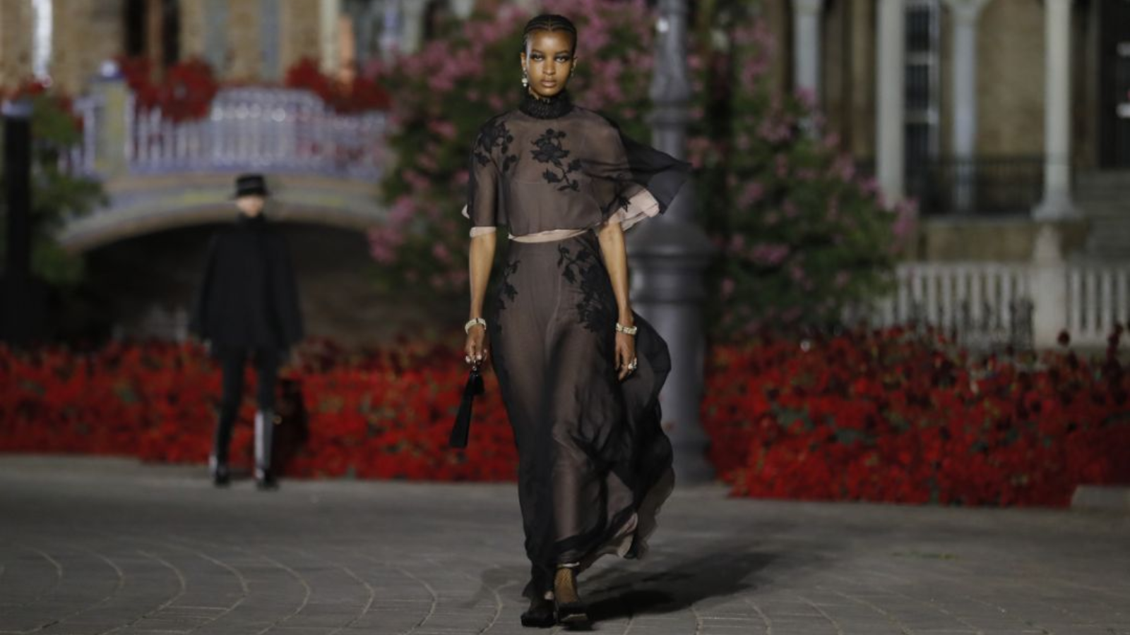 Modelo desfilando con un traje negro de Dior y un abanico fabricado en Valencia